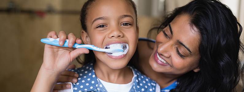 mom with daughter brushing teeth