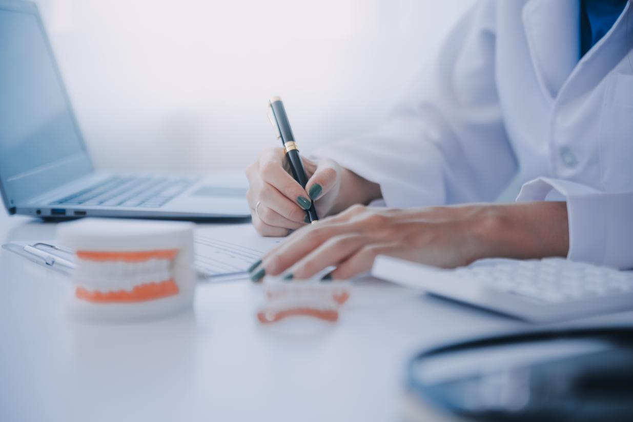 dentist writing notes in front of computer