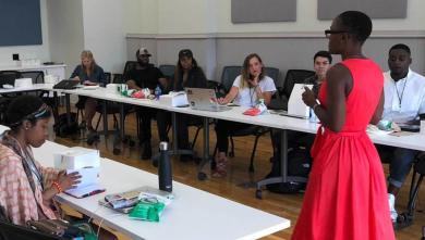 Woman in red dress stands in front of classroom